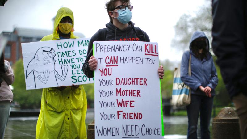 A transgender man holds a banner as pro-abortion rights protesters gather on May 7, 2022, in New York City.