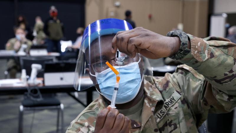 SGT Derrick Ngbome of the Illinois Army National Guard prepares a COVID-19 vaccine at a mass vaccination center established at the Tinley Park Convention Center on January 26, 2021 in Tinley Park, Illinois.