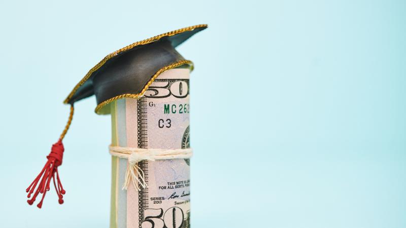Money roll in graduation cap, stock photo
