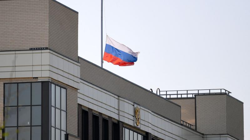 A Russian flag flies at half-mast on top of the Sovetsky district court in memory of victims of the school shooting, in Kazan on May 12, 2021.