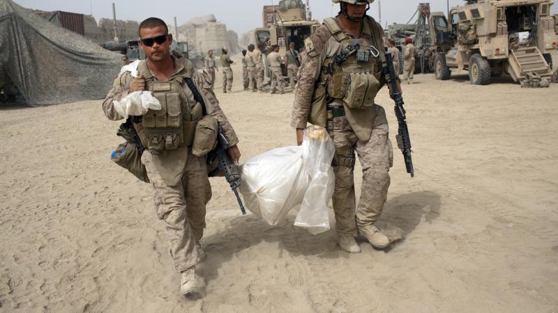 Marines carrying trash, Afghanistan, Aug. 15, 2009
