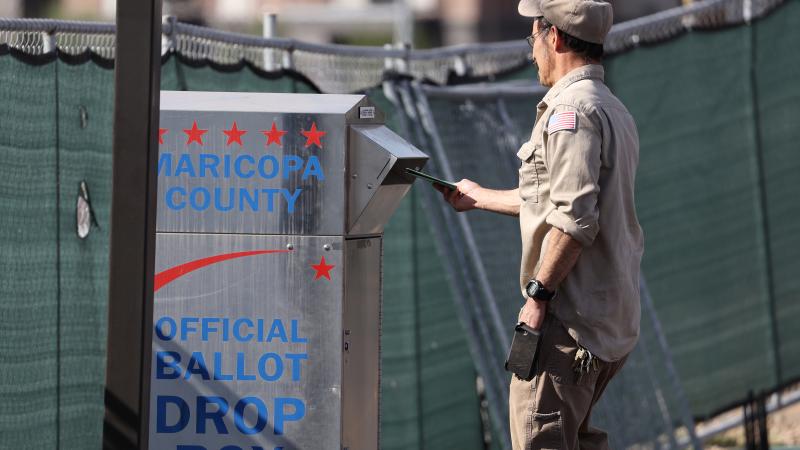 A voter drops his ballot into a drop box at the Maricopa County Tabulation and Election Center on November 07, 2022 in Phoenix, Arizona.
