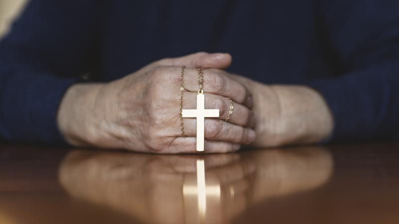 Catholic in prayer with Rosary 