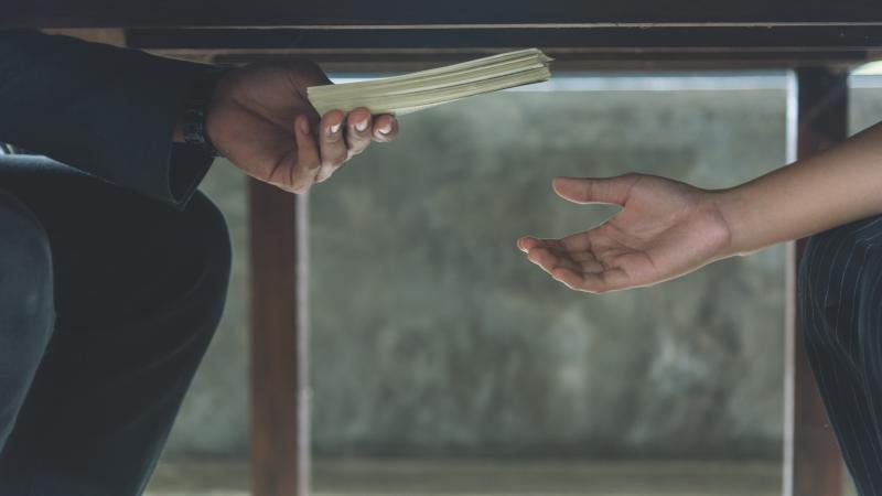 Papers being passed under the table
