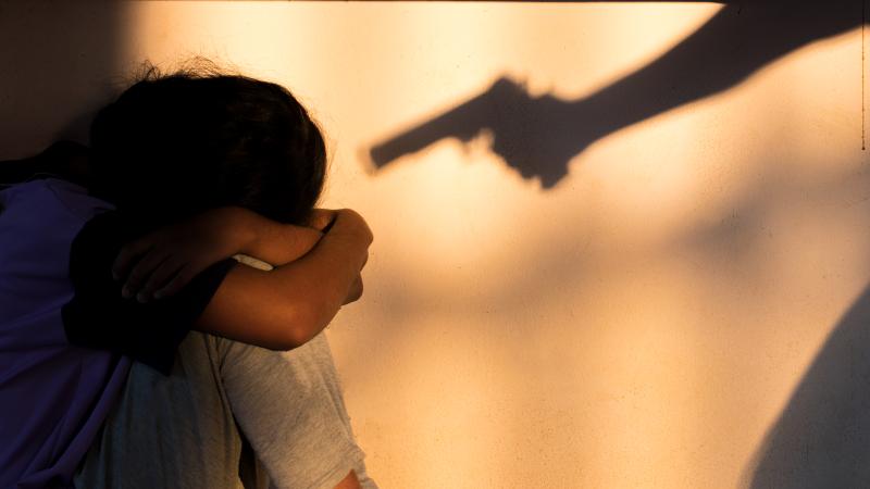 Gun pointed at woman, stock photo