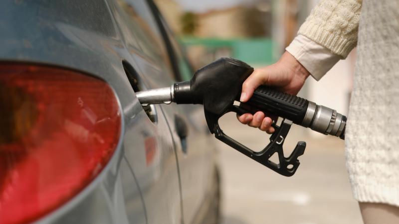 A woman pumps gas at the gas station