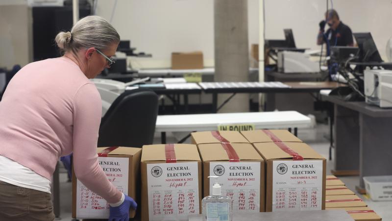 An election worker places a box of scanned ballots on a pallet at the Maricopa County Tabulation and Election Center on November 10, 2022 in Phoenix, Arizona.