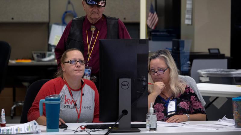 An adjudication board reviews ballots at the Maricopa County Tabulation and Election Center on November 09, 2022 in Phoenix, Arizona.