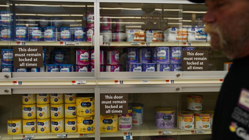 Customer walking past a locked shelf in a Giant supermarket
