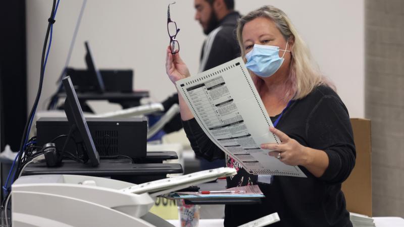 An elections worker scans mail in ballots at the Maricopa County Tabulation and Election Center on November 07, 2022 in Phoenix, Arizona