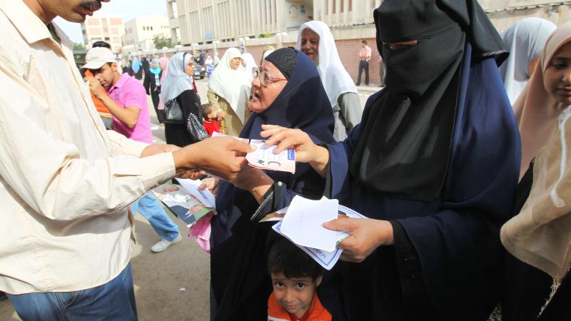 Egyptian women have their papers checked prior to casting their vote outside a school campus in the al-Seuoff district of the Egyptian port city of Alexandria 