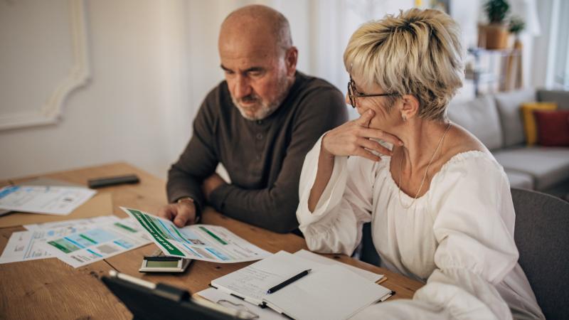 Couple calculating bills and taxes, stock photo