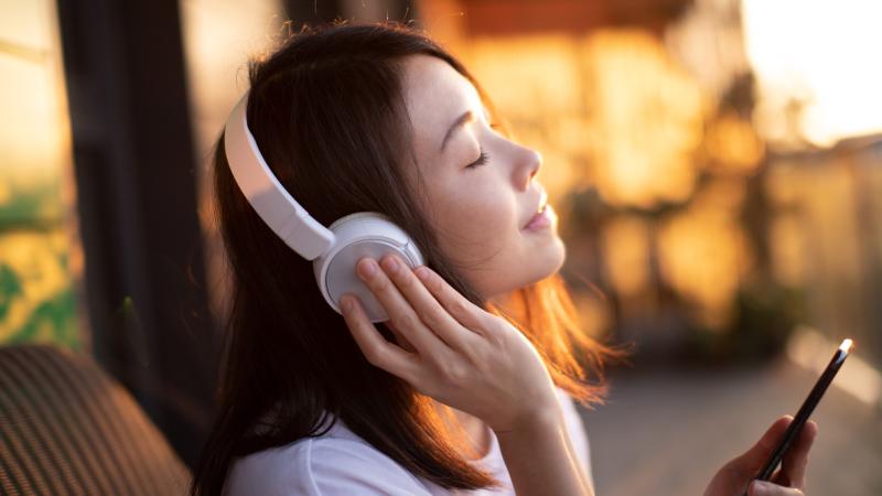 Woman listens to music, phone, stock photo