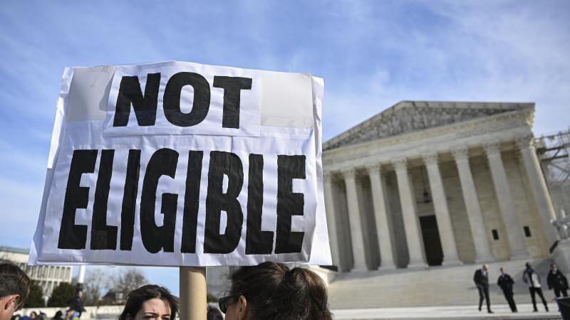 Demonstrators hold "Trump is a traitor" banners outside the US Supreme Court during the hearing in Washington, United States on February 8, 2024