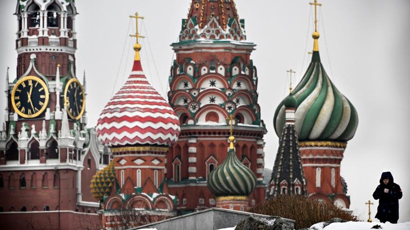 A man in front of St. Basil's Cathedral in Moscow. (Photo by ALEXANDER NEMENOV/AFP via Getty Images)