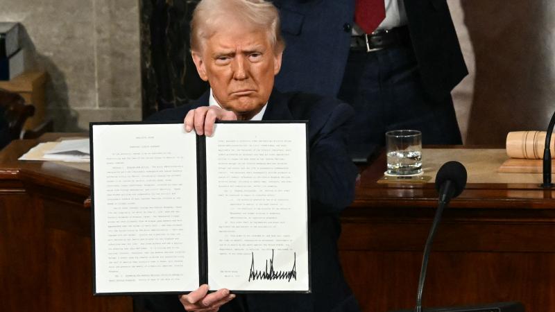 US President Donald Trump holds up an executive order that renames a wildlife sanctuary in honor of the late Jocelyn Nungaray, a 12 year-old girl who was murdered by two undocumented migrants, during an address to a joint session of Congress at the US Capitol in Washington, DC, on March 4, 2025.
