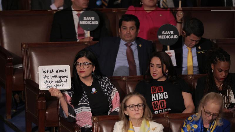 Democrats hold protest signs as U.S. President Donald Trump address a joint session of Congress at the U.S. Capitol on March 04, 2025 in Washington, DC.