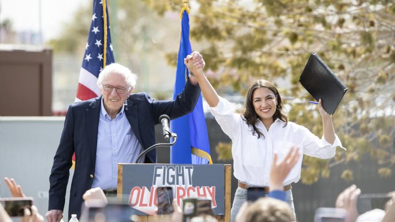 Bernie Sanders, I-Vt., left, joins Rep. Alexandria Ocasio-Cortez, D-N.Y., on stage before speaking at Fighting Oligarchy