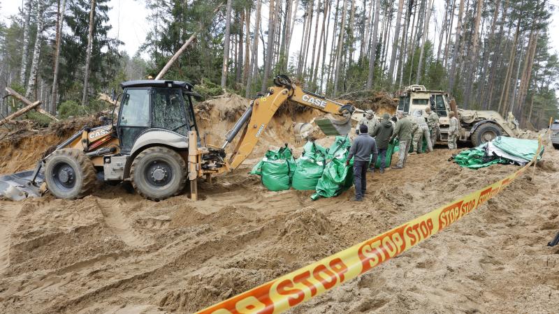 Military personnel work at the site of a rescue operation for missing US soldiers at Pabrade training ground, in Lithuania, on March 28, 2025.