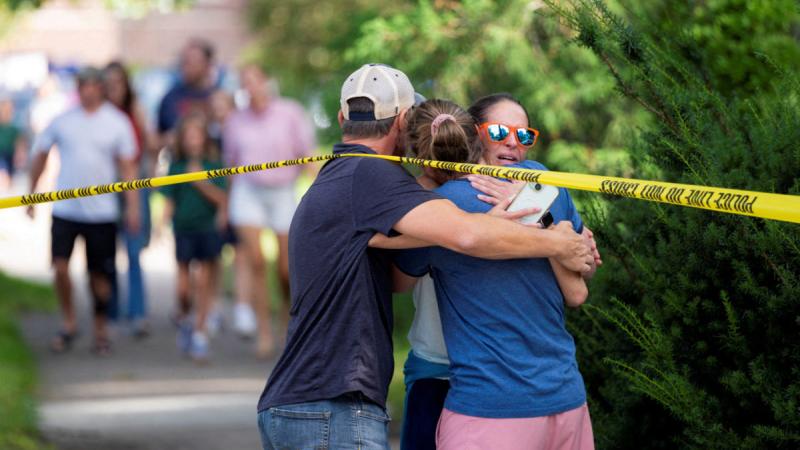 Families and loved ones reunite outside the police barricades after a shooting at Annunciation Church
