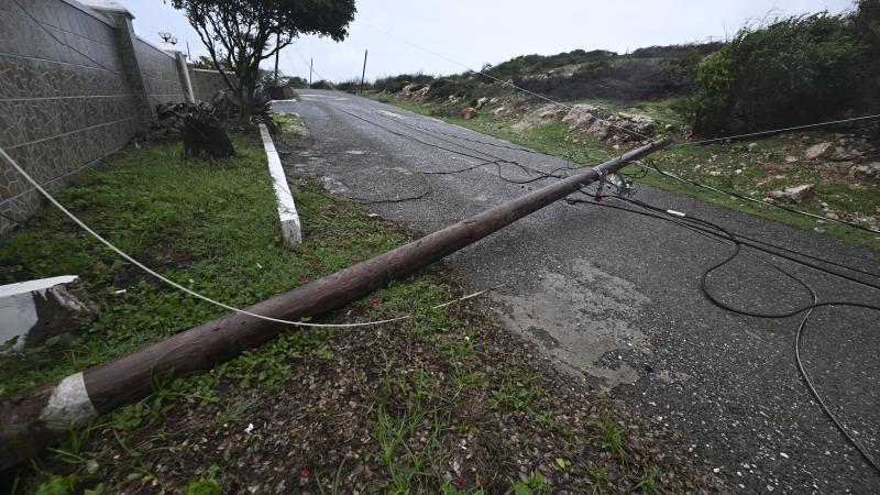 A fallen Jamaica Public Service Company light pole is seen on the Sugar Man's beach main road in Hellshire, St Catherine parish, near Portmore, as Jamaica starts to feel the effects of Hurricane Melissa on October 26, 2025