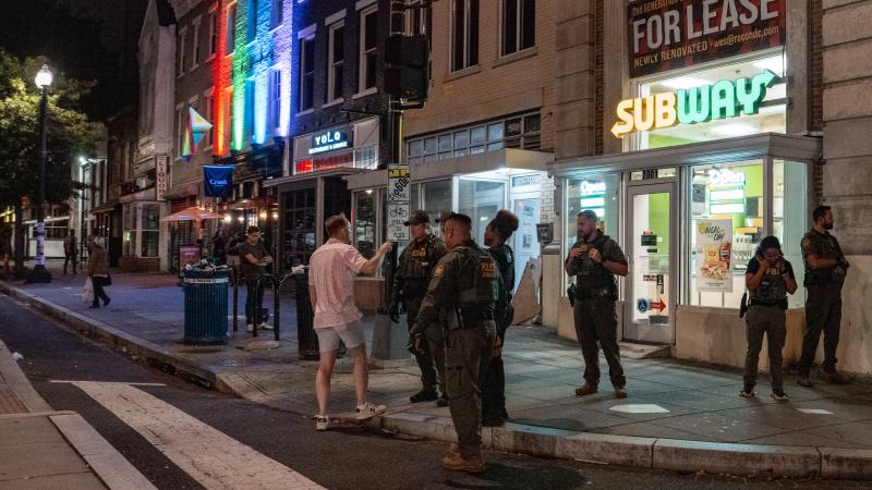 FBI and Border Patrol officers speak with Sean Charles Dunn, after he allegedly assaulted law enforcement with a sandwich, along the U Street corridor during a federal law enforcement deployment to the nation's capital on August 10, 2025 in Washington, DC
