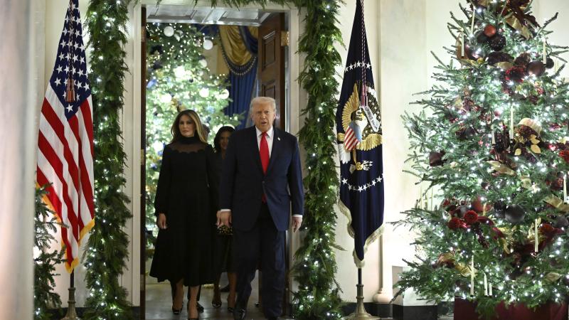 President Donald Trump and First Lady Melania walk among Christmas decorations en route to the East Room at the White House on Dec. 5, 2025 in Washington, DC.