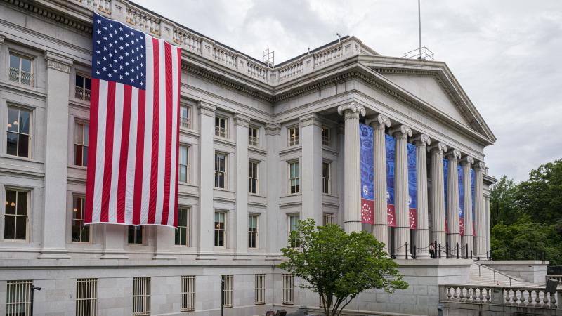 The U.S. flag hangs next to the north entrance of the Treasury Department's headquarters building on May 27 in Washington, D.C.