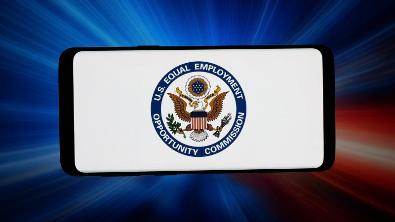 In this photo illustration, the logo of Equal Employment Opportunity Commission (EEOC) is displayed on a smartphone in front of abstract background on computer screen. 