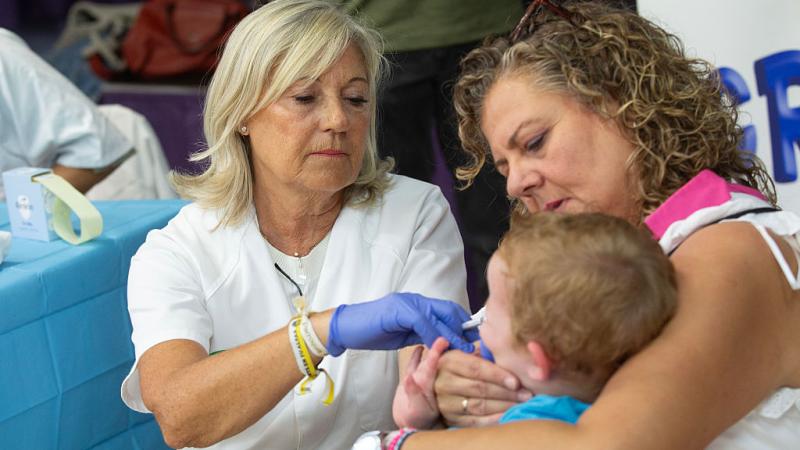 Nurse gives vaccine to child at school