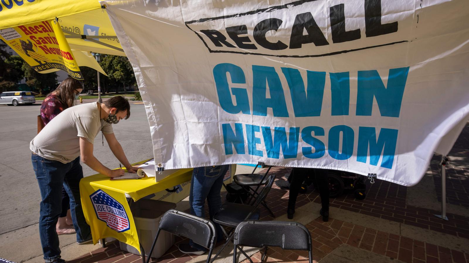 A man signs a petition as conservative activists gather signatures in a recall effort against California Governor Gavin Newsom near Pasadena City Hall, in Pasadena, California on February 28, 2021