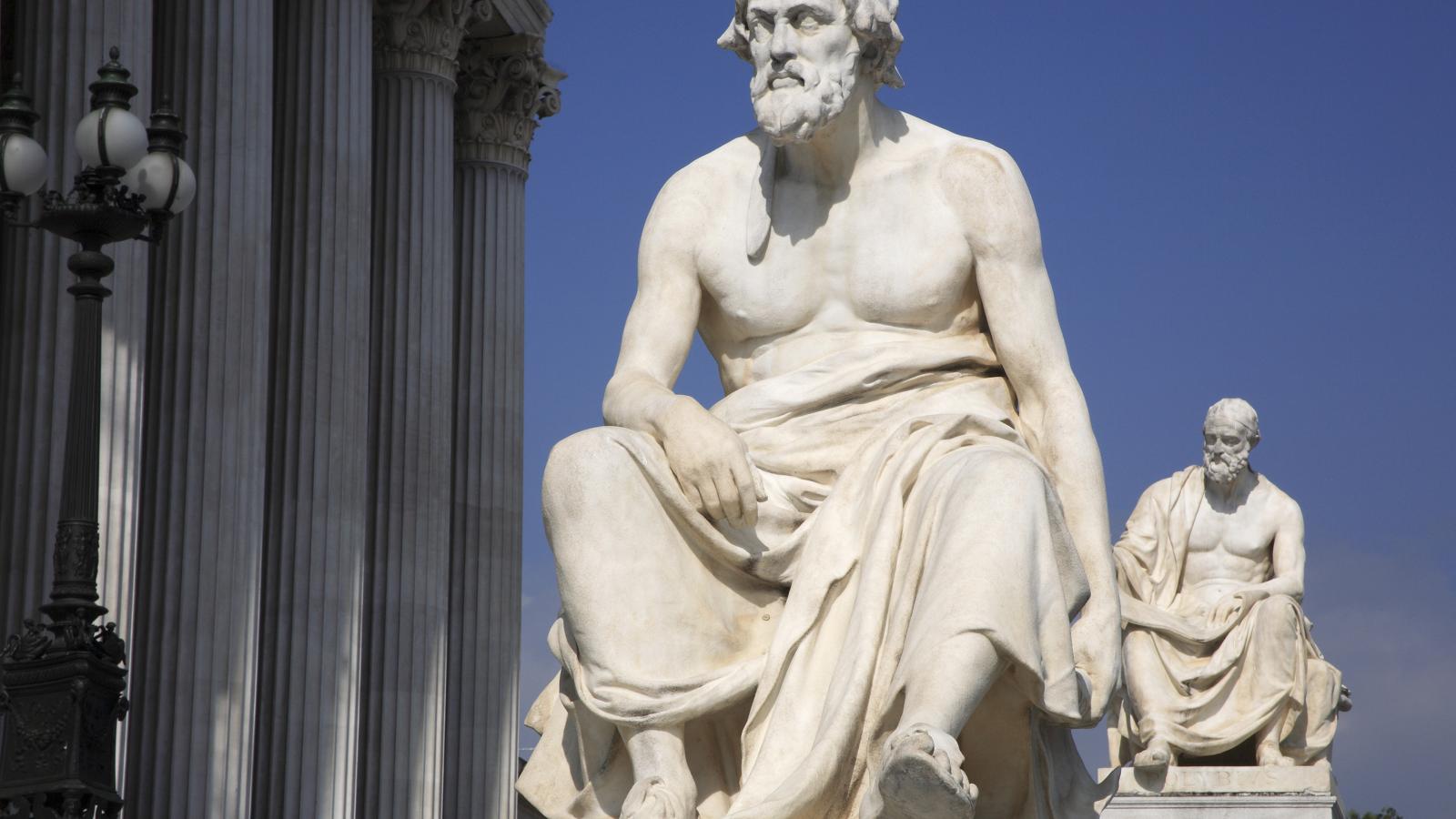 Austria, Vienna, Statue of the Greek philosopher Thucydides in front of the columns to the Parliament Building.