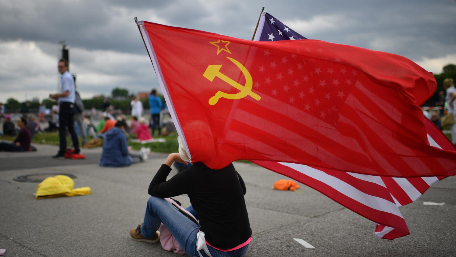 A protester waves flags of the Soviet Union and of the USA prior to a demonstration against lockdown measures and government policy during the coronavirus crisis on May 23, 2020 in Munich, Germany.