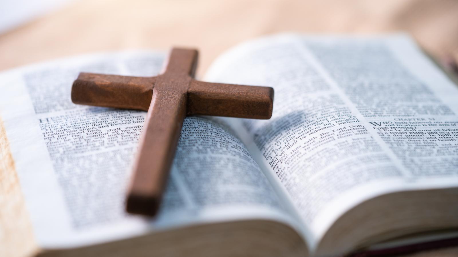 The cross is placed on the Bible.